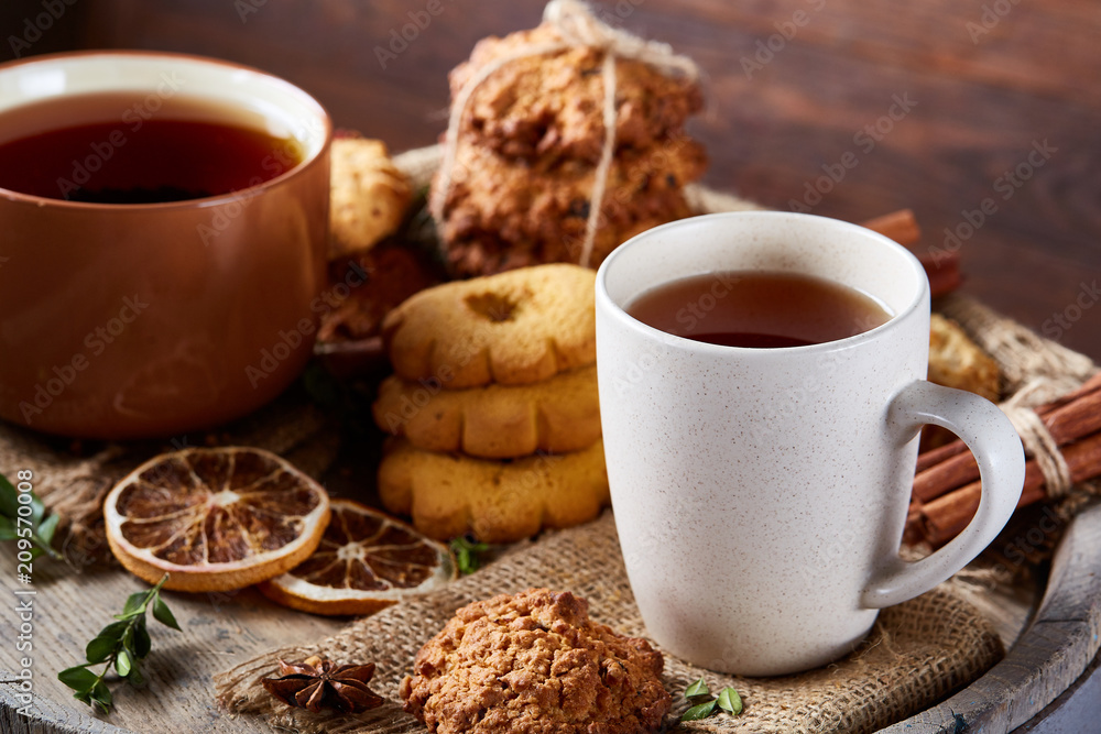 White porcelain mug of tea and sweet cookies on wooden background, top view, selective focus White porcelain mug of tea and sweet cookies on wooden background, top view, selective focus