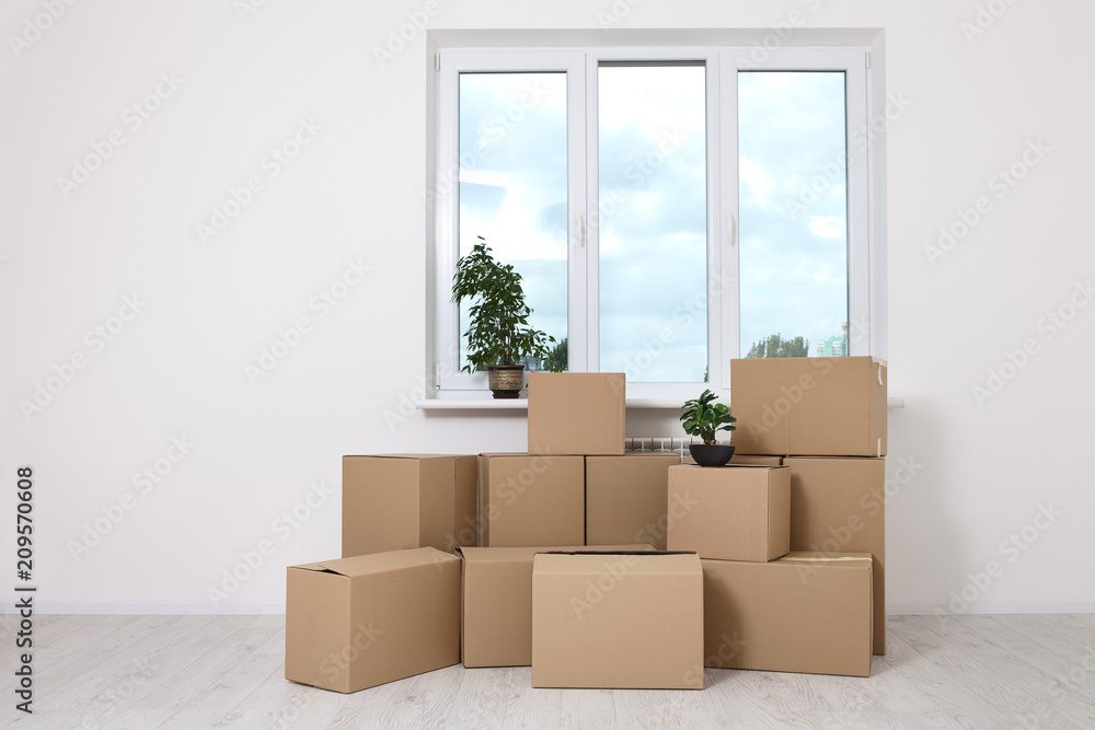 Moving into a new apartment. Move lots of cardboard boxes in an empty new apartment. Moving into a new apartment. Move lots of cardboard boxes in an empty new apartment.