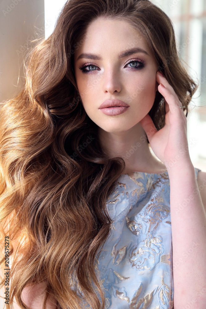 Obraz premium beautiful woman with dark hair in elegant dress walking on the street in summer city
