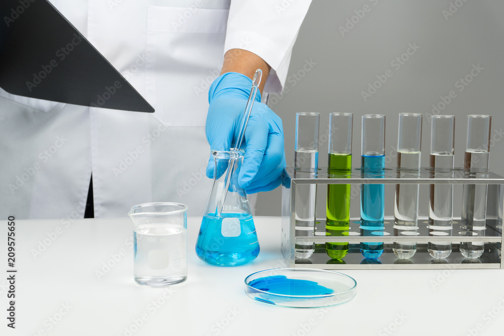 laboratory scene, the scientist holding the glass stirring rod