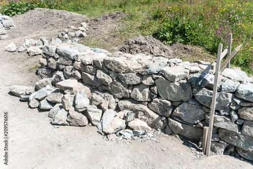 traditional rock wall construction site with wooden frame in the Swiss Alps photo