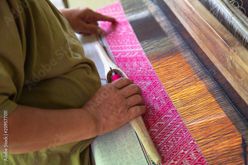 The hands of old woman weaving, the ancient weaving method.