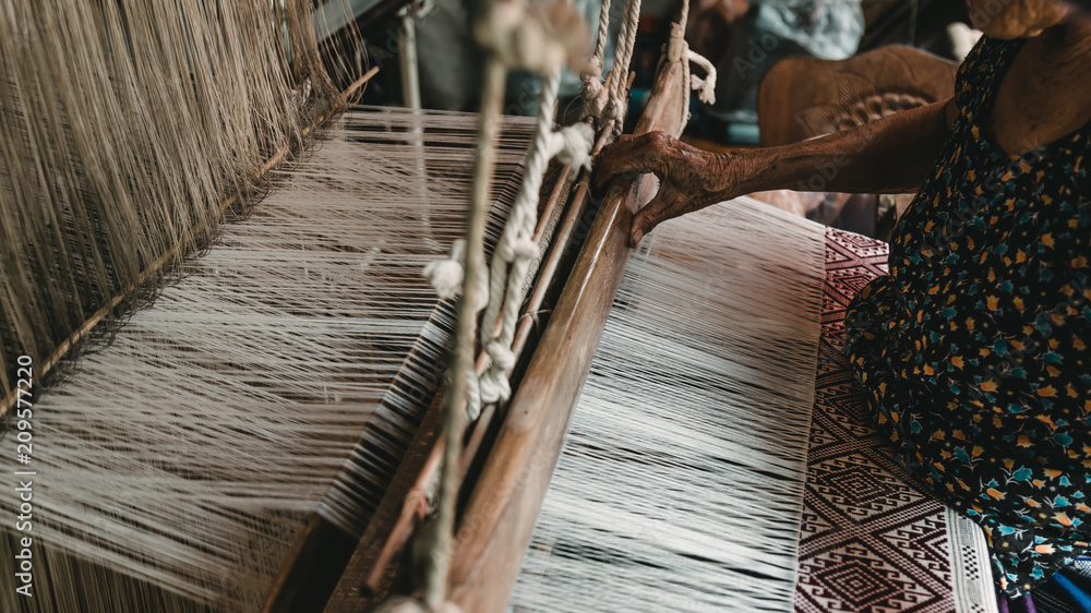 The hands of old woman weaving, the ancient weaving method.