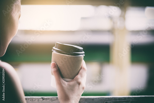 Asian woman traveler has drinking coffee in the train with happiness at Hua Lamphong station at Bangkok, Thailand.