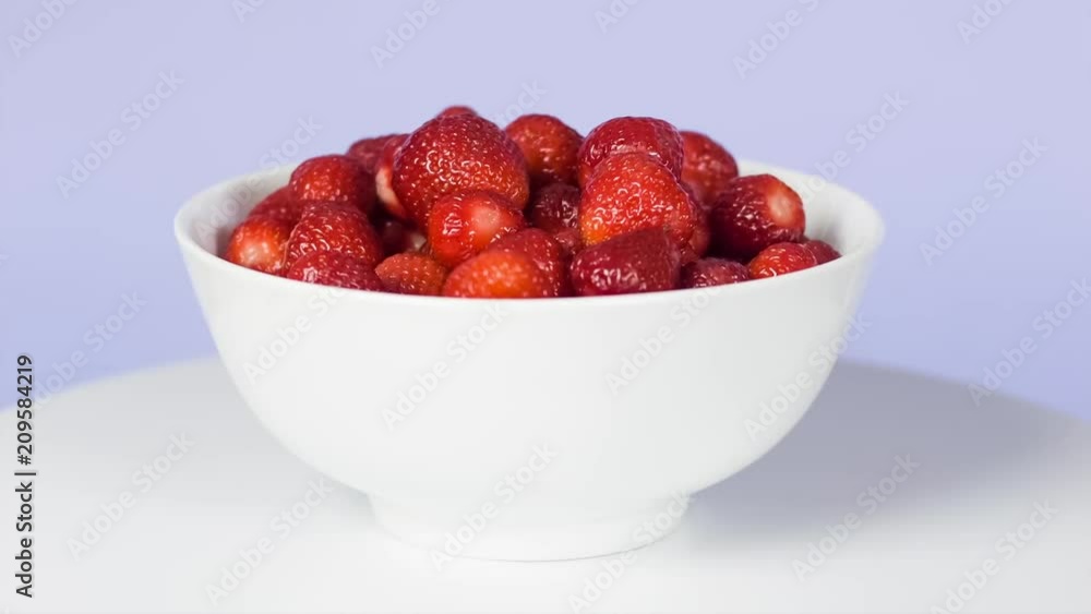 Fresh strawberries in a whte bowl. Rotation. purple background. turntable 360 degree shot. still life Fresh strawberries in a whte bowl. Rotation. purple background. turntable 360 degree shot. still life
