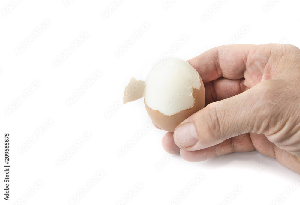Peeling off the hard egg shell with hands on the white Peeling off the hard egg shell with hands on the white