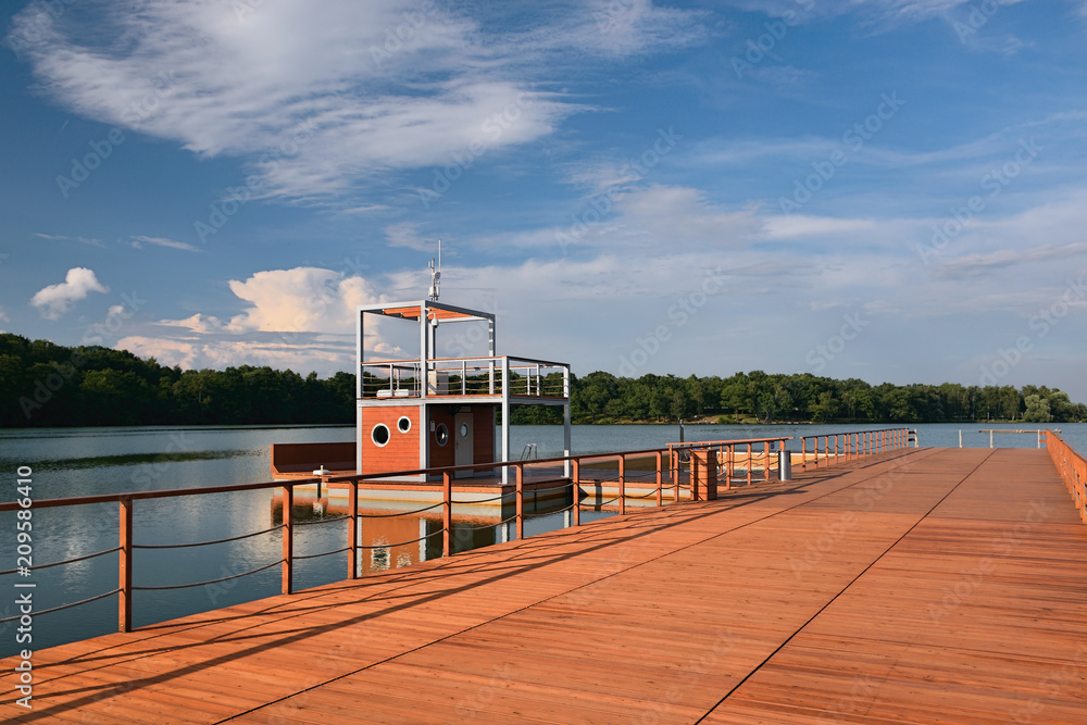 Obraz premium New wooden molo with small tower on Kamencove jezero alum lake in czech city of Chomutov at evening after rain in June 2018