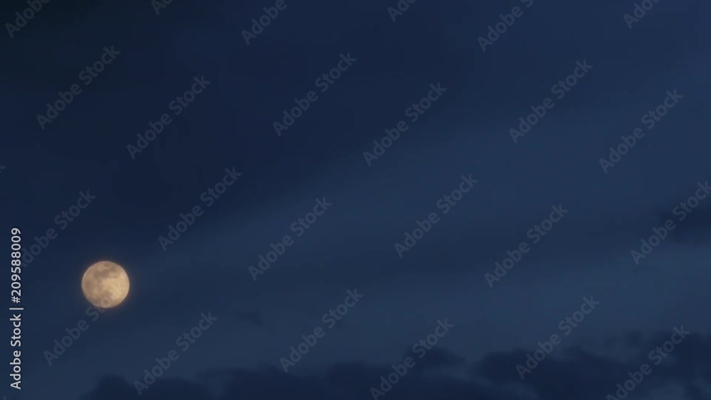Time lapse of moving dark blue clouds and shining moon. Dramatic cloudy sky. Cloudscape at nighttime Time lapse of moving dark blue clouds and shining moon. Dramatic cloudy sky. Cloudscape at nighttime