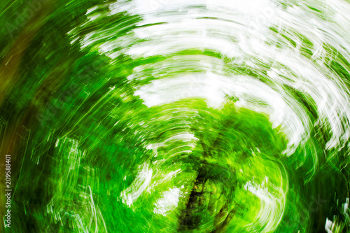 Abstract green blurred background with motion and rotation, photo © savelov