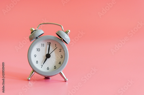 alarm clock on pink background. Vintage style alarm clock with copy space for text.