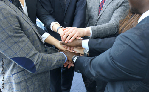 Businessman team in suit touching hands together. Selective focus.