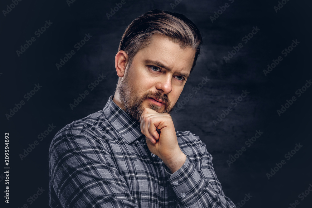 Pensive middle age man with beard and hairstyle dressed in a checkered shirt pose with hand on chin. Pensive middle age man with beard and hairstyle dressed in a checkered shirt pose with hand on chin.
