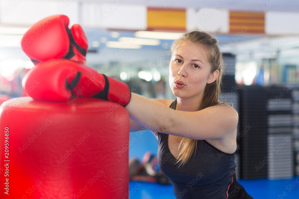 Portrait of active female with  punching bag