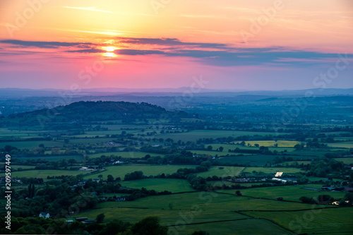 Sunset viewed from Crickley Hill looking towards Gloucester and the hills in the distance. photo