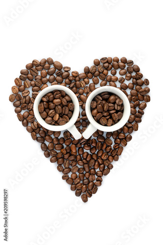 Shape of heart made from roasted coffee beans and two espresso cups. isolated on white background