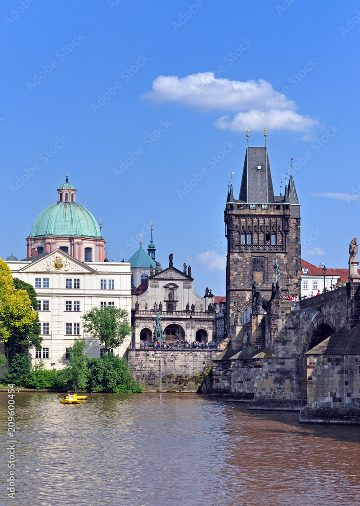 View from the Vltava River to Charles Bridge, the Old Town Tower and the Church of St. Francis of Assisi. Prague, Czech Republic, Europe