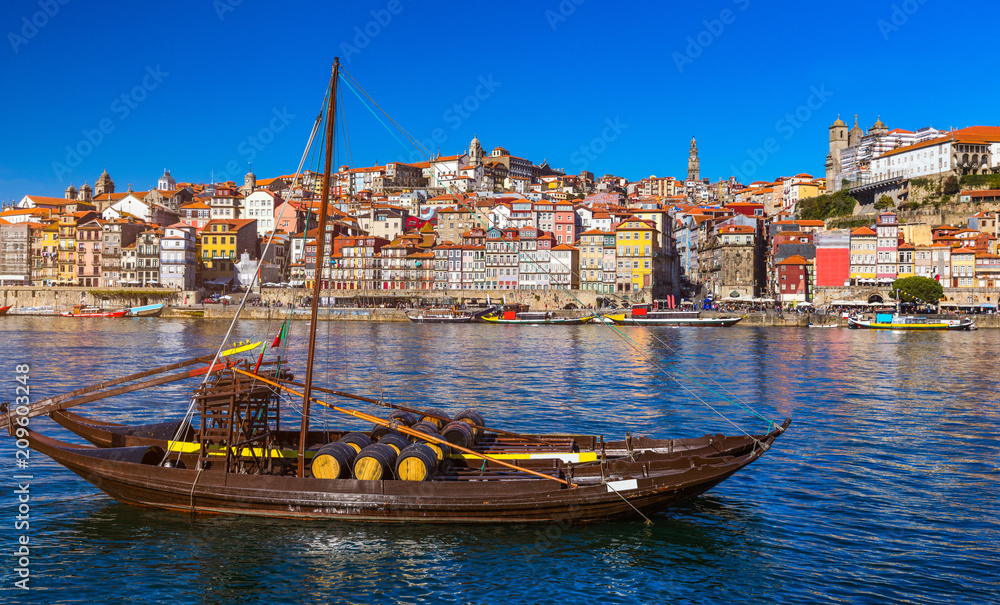 Obraz premium Port wine boats at the waterfront with the old town on the Douro River in Ribeira in the city centre of Porto in Porugal, Europe. Portugal, Porto