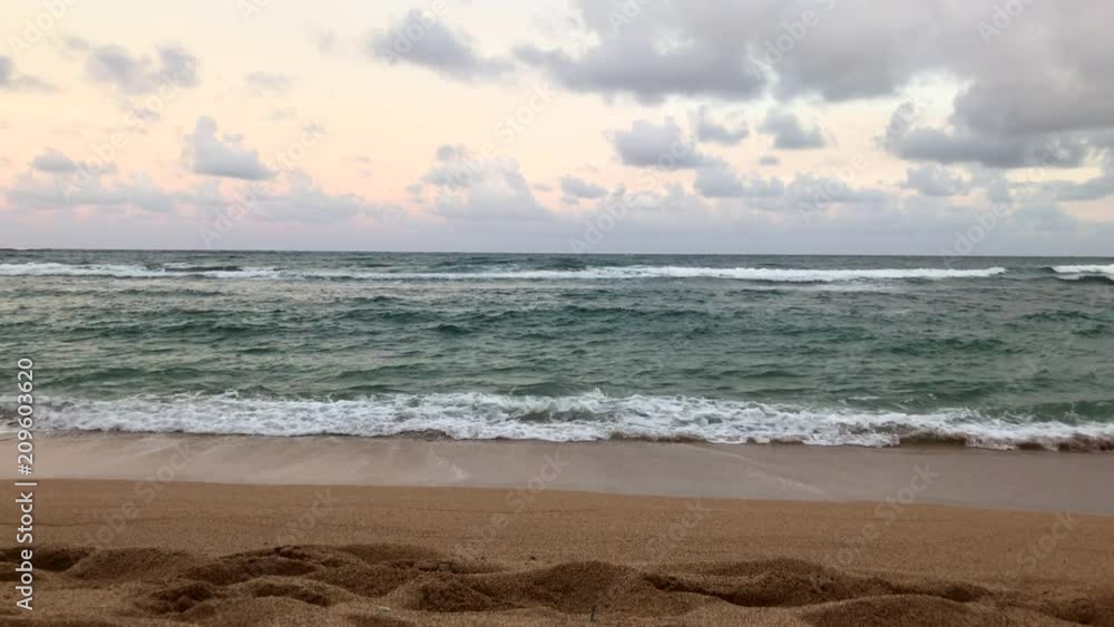 Ocean waves break on a beautiful, tropical beach during a summer afternoon. Ocean waves break on a beautiful, tropical beach during a summer afternoon.