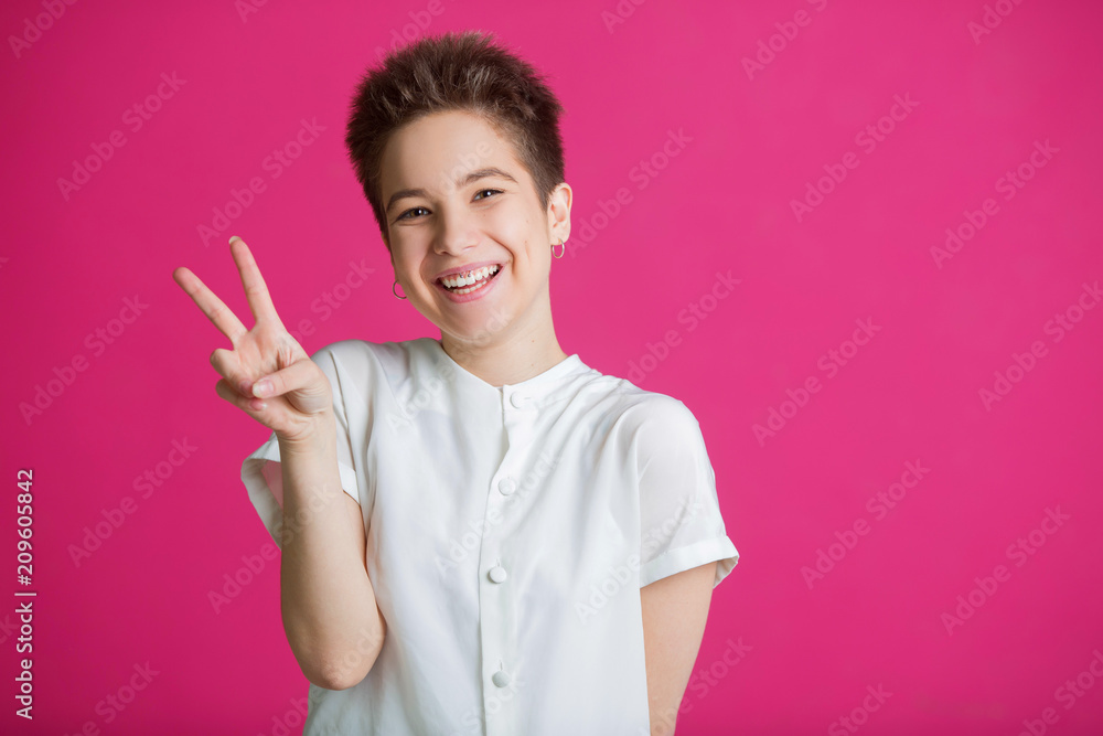 beautiful young girl with short hairdo in a white t-shirt on a pink background beautiful young girl with short hairdo in a white t-shirt on a pink background