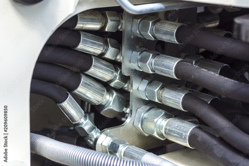 Close up of pipe system of hydraulic valves in agricultural machinery Close up of pipe system of hydraulic valves in agricultural machinery
