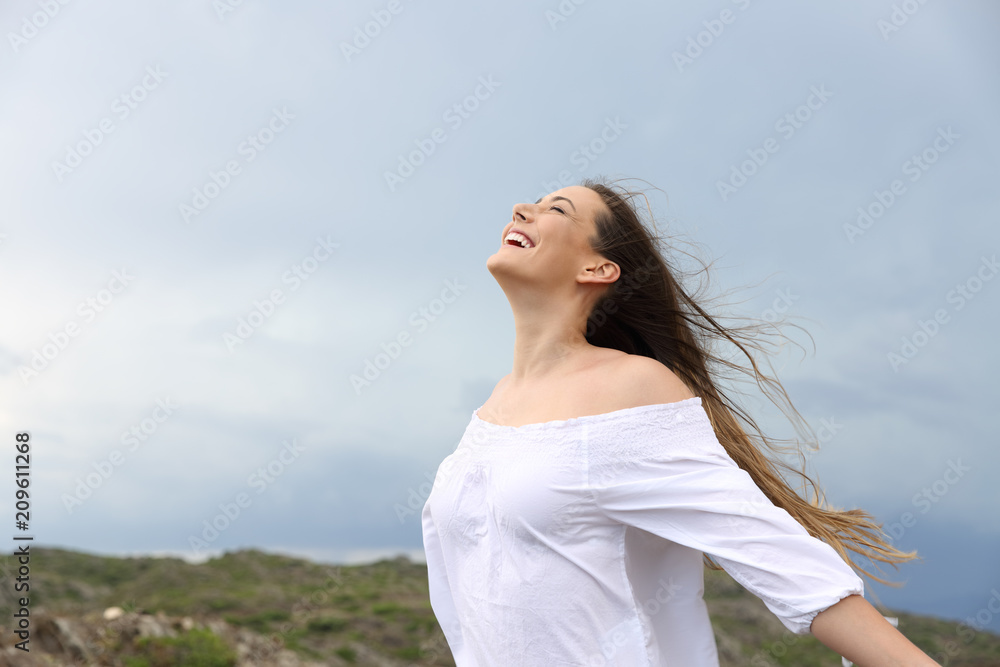 Positive woman breathing enjoying the wind
