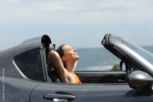 Relaxed tourist in a roadster car on summer vacations