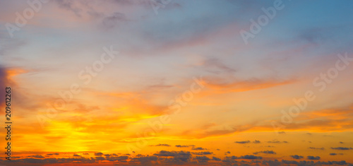 Cloudy sky and bright sun rise over the horizon.