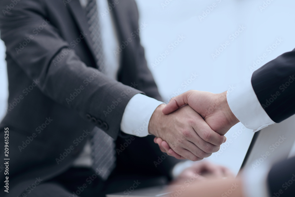 Closeup of business people shaking hands over a deal Closeup of business people shaking hands over a deal