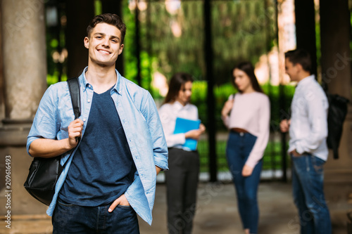 Fotografie Smiling student in front of a group of friends at campus