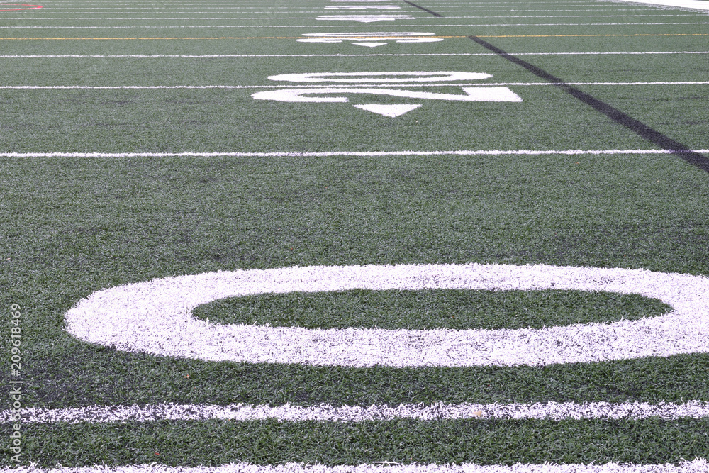 artificial turf football field close-up on the yard markers.