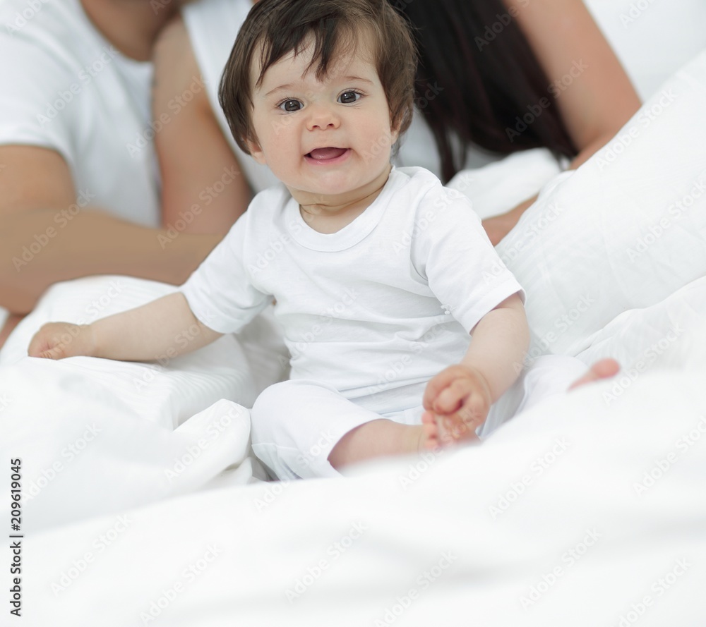 Portrait of a joyful family sitting on the bed at home Portrait of a joyful family sitting on the bed at home