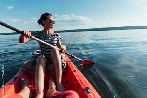   girl sails on a kayak, paddles with a paddle.