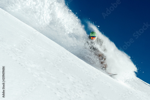 man snowboarder is going very fast freeride in stream of snow avalanche