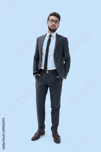 Young businessman standing with hands in pockets.