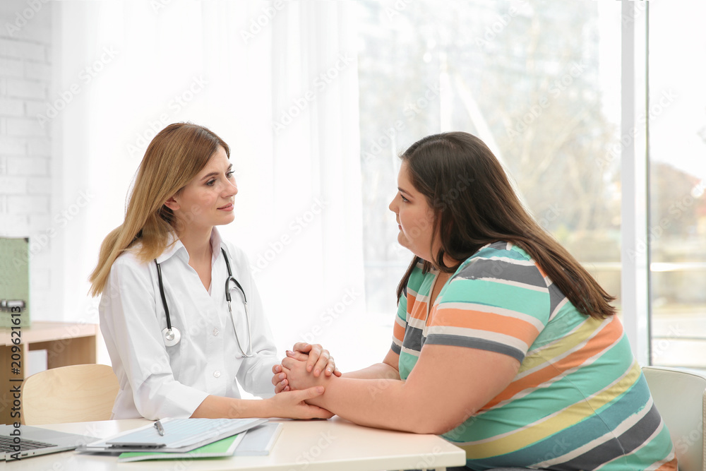 Female doctor consulting overweight woman in clinic Female doctor consulting overweight woman in clinic