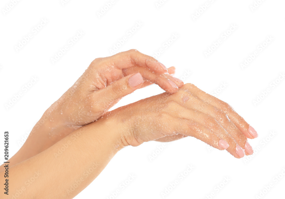 Young woman applying natural scrub on hands against white background Young woman applying natural scrub on hands against white background