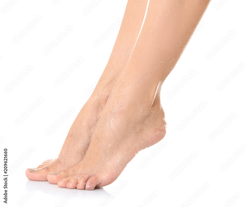 Female legs with applied natural scrub against white background Female legs with applied natural scrub against white background