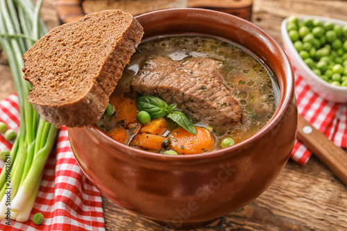 Fotografi Crock pot with stewed meat on table