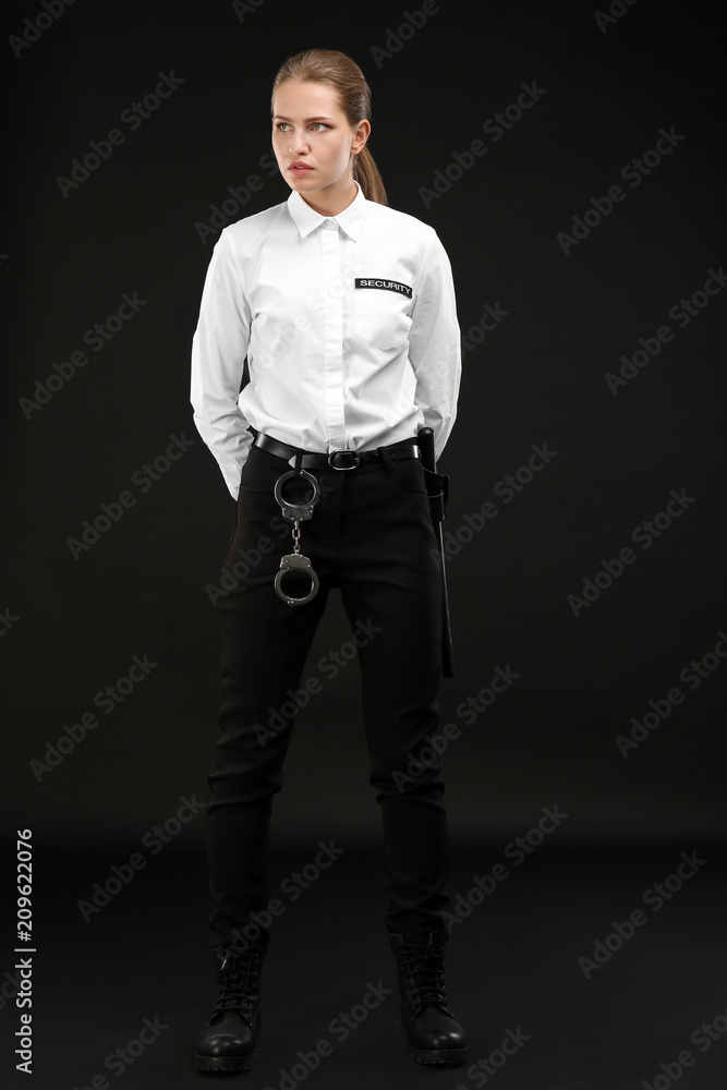 Female security guard in uniform on dark background Female security guard in uniform on dark background