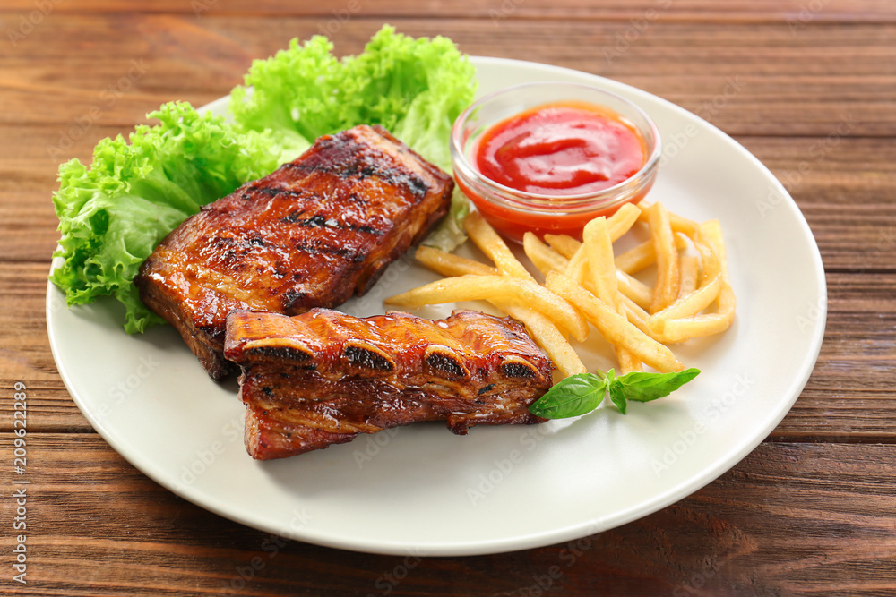 Plate with delicious grilled ribs on table Plate with delicious grilled ribs on table