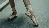 Close up of practice makes perfect- ballerina practices on the dancing hall. Image of ballet shoes in the action. 