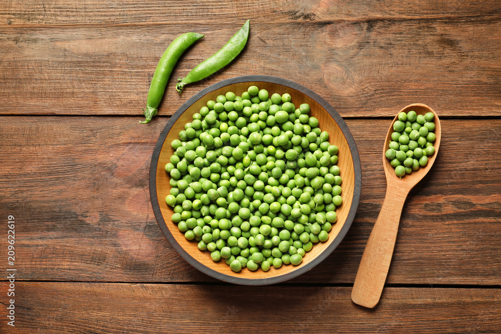 Flat lay composition with green peas on wooden background Flat lay composition with green peas on wooden background