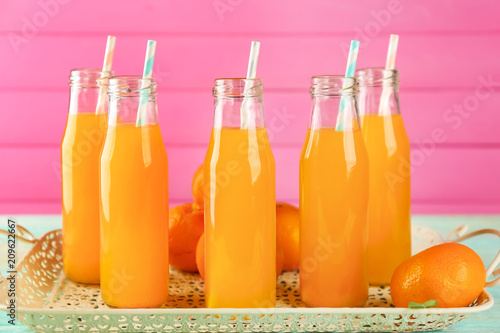 Fotografie Bottles with fresh citrus juice on tray