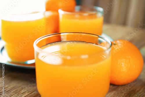 Glass with fresh citrus juice on table, closeup
