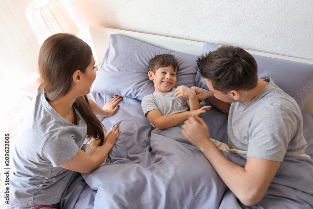 Parents with little son in bed. Family bedtime