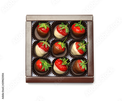 Box with chocolate covered strawberries on white background, top view