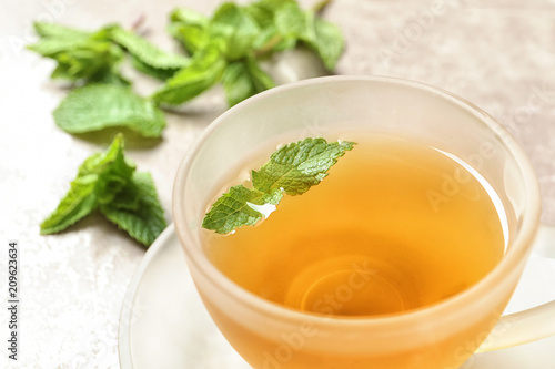 Cup with hot aromatic mint tea, closeup