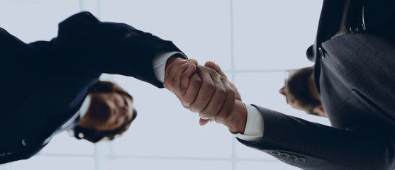 Two business people are holding hands to business cooperation.