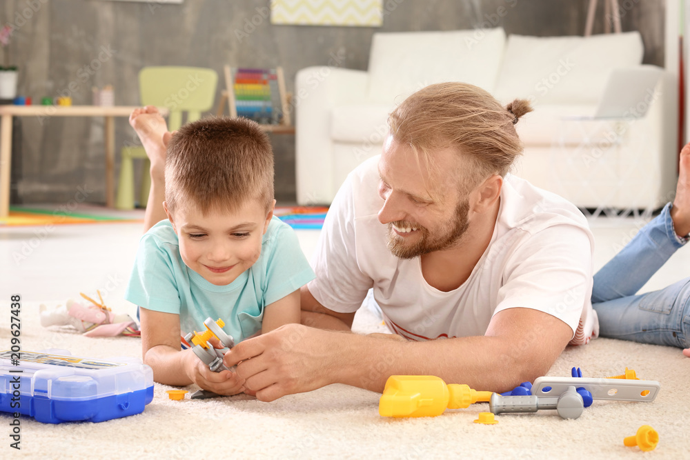 Father playing with cute son at home Father playing with cute son at home