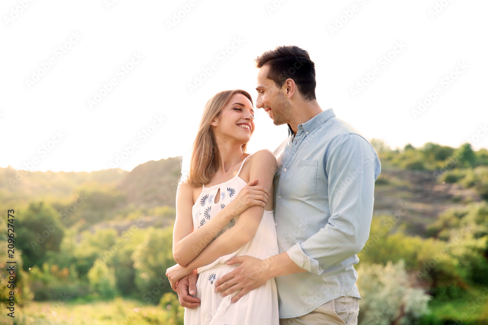 Cute young couple in love posing outdoors on sunny day Cute young couple in love posing outdoors on sunny day
